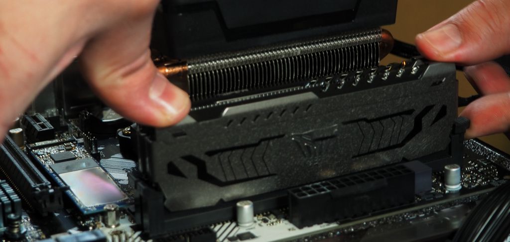Person installing RAM modules onto motherboard