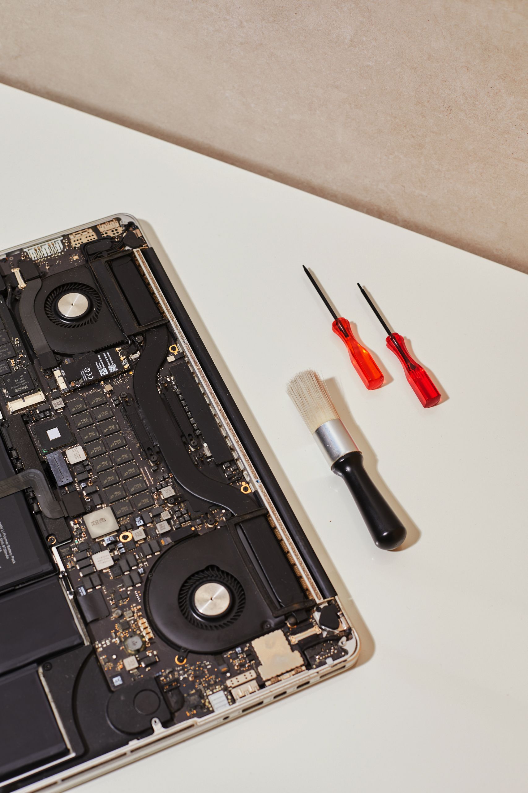 Laptop motherboard exposed with screwdrivers